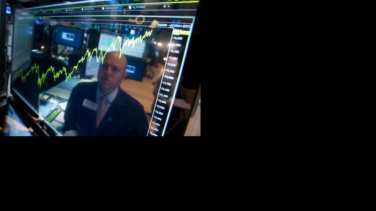 
Specialist Jay Woods is reflected in a screen at his post in a photo from July. The market had a better year than most analysts had predicted, although the Nasdaq and Standard & Poor’s index outperformed the Dow.

