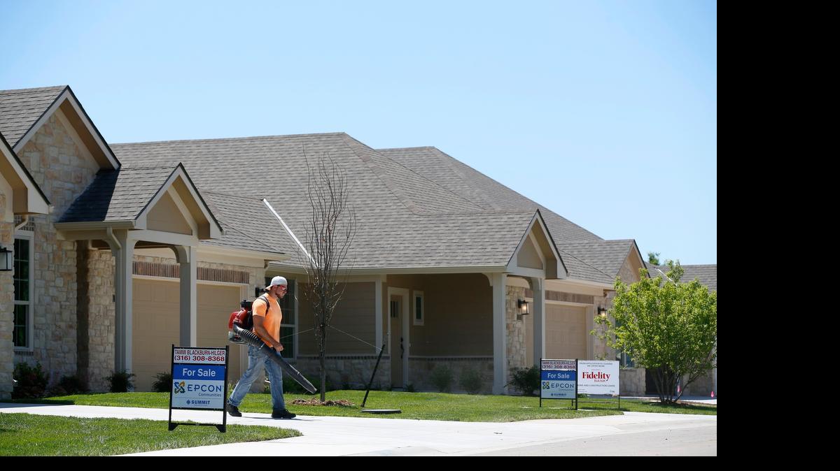 
A worker clears debris from around a home for sale at The Courtyards At Auburn Hills, a new courtyard home community. Area home sales showed an increase in April, according to local real estate officials.
