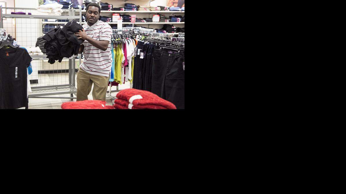 
Towne East J.C. Penney employee Derreck Andrews stocks sweaters for Thanksgiving Day sales. (Nov. 18, 2014)
