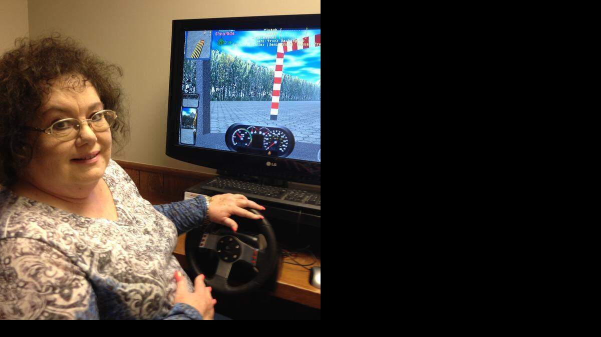 
Tandy Noeller, owner of the Wichita Truck Driving School, sits at a simulator used by students. Noeller started her business in 2011.
