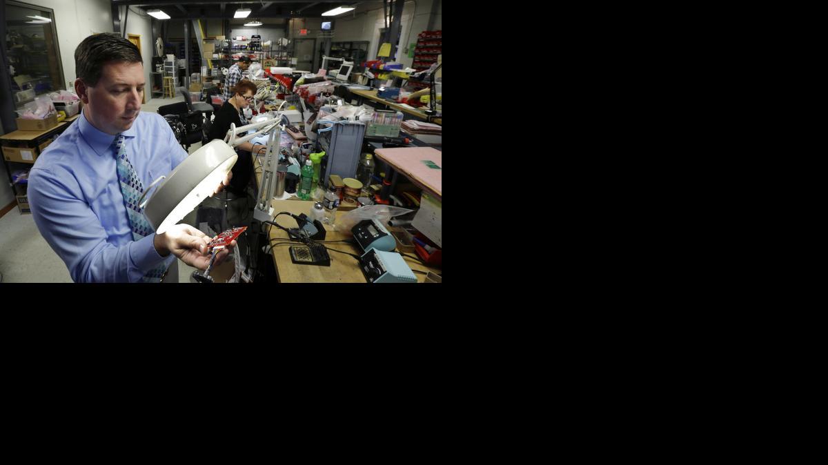 
Scott Schober uses a magnifier to look at a circuit board for a cellular telephone detector at Berkeley Varitronics Systems, in Metuchen, N.J. Berkeley Varitronic Systems’ bank account was hacked earlier this year and $50,000 was taken, Schober says. He got the money back, but considers the incident a lesson. 
