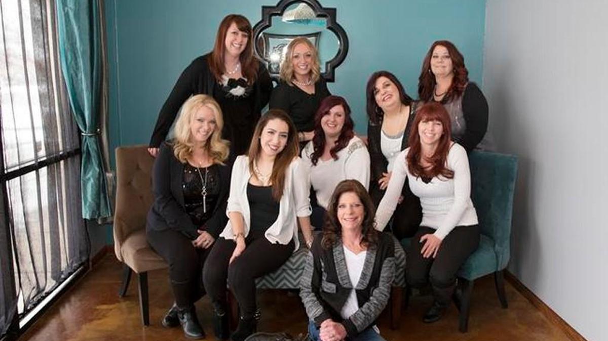 Salon Lavish owner Lacey Smith, standing in the center of the back row, poses with some of the stylists who work at her salon.