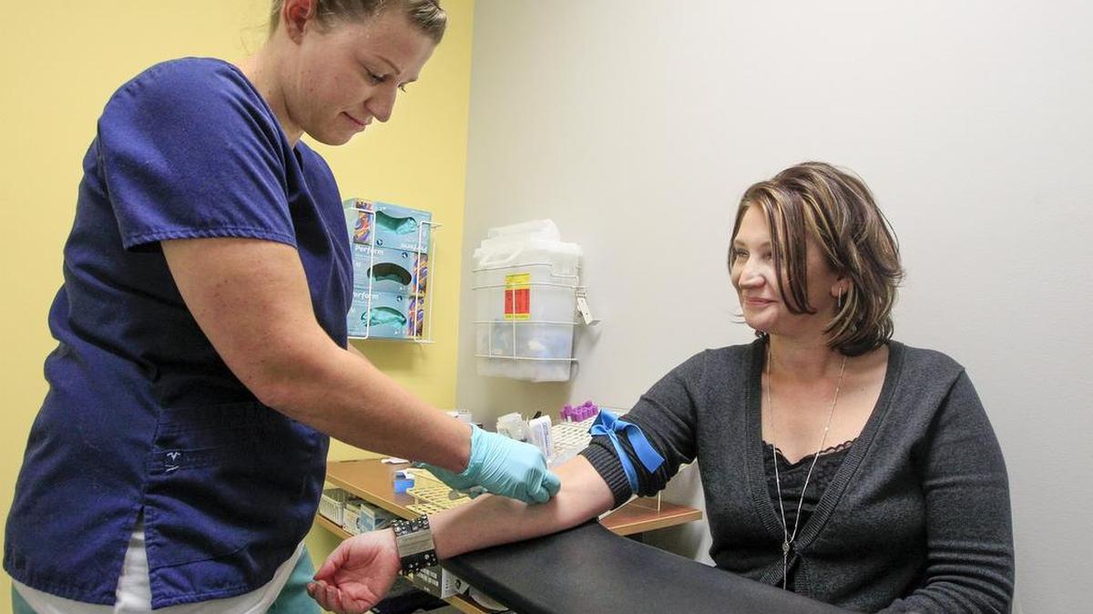 Christy Eckhoff, right, has her blood drawn by phlebotomist Susan Edwards on Tuesday at Affordalab, which offers medical tests at affordable prices. (Nov. 22, 2016)