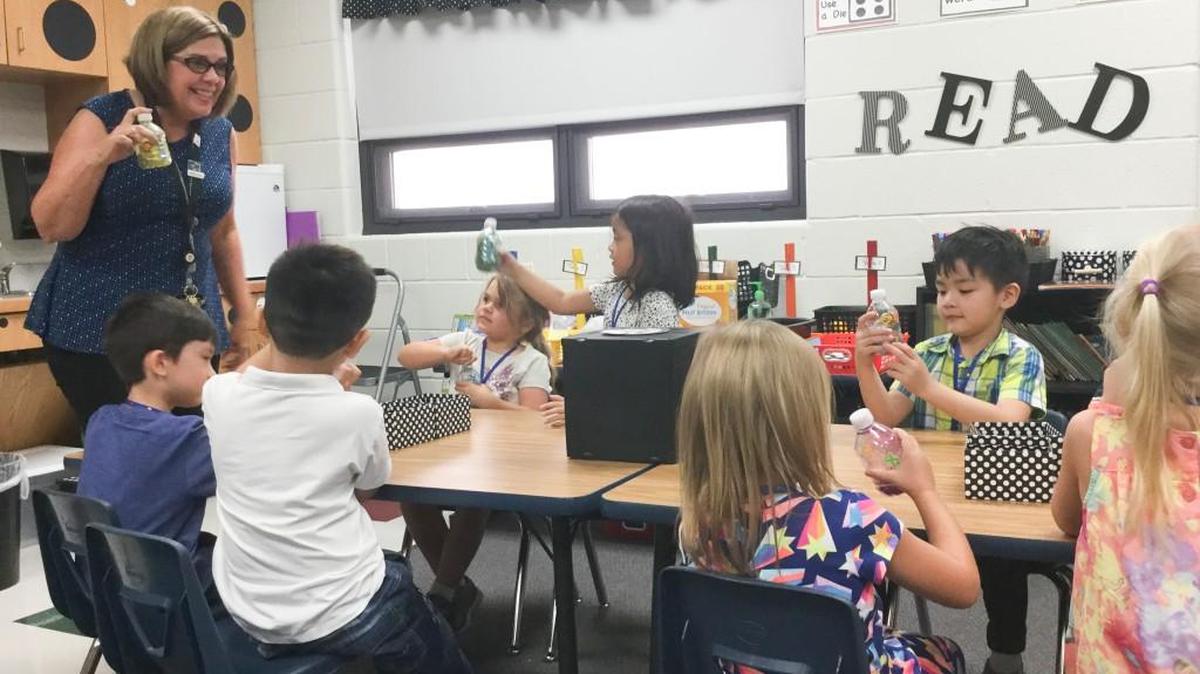 Cathy Boote, a kindergarten teacher at Christa McAuliffe Academy in Wichita, helps students with a craft project. Education is one of the few sectors that will be expanding in terms of jobs in the Wichita area next year, according to a new jobs forecast from Wichita State University’s Center for Economic Development and Business Research.