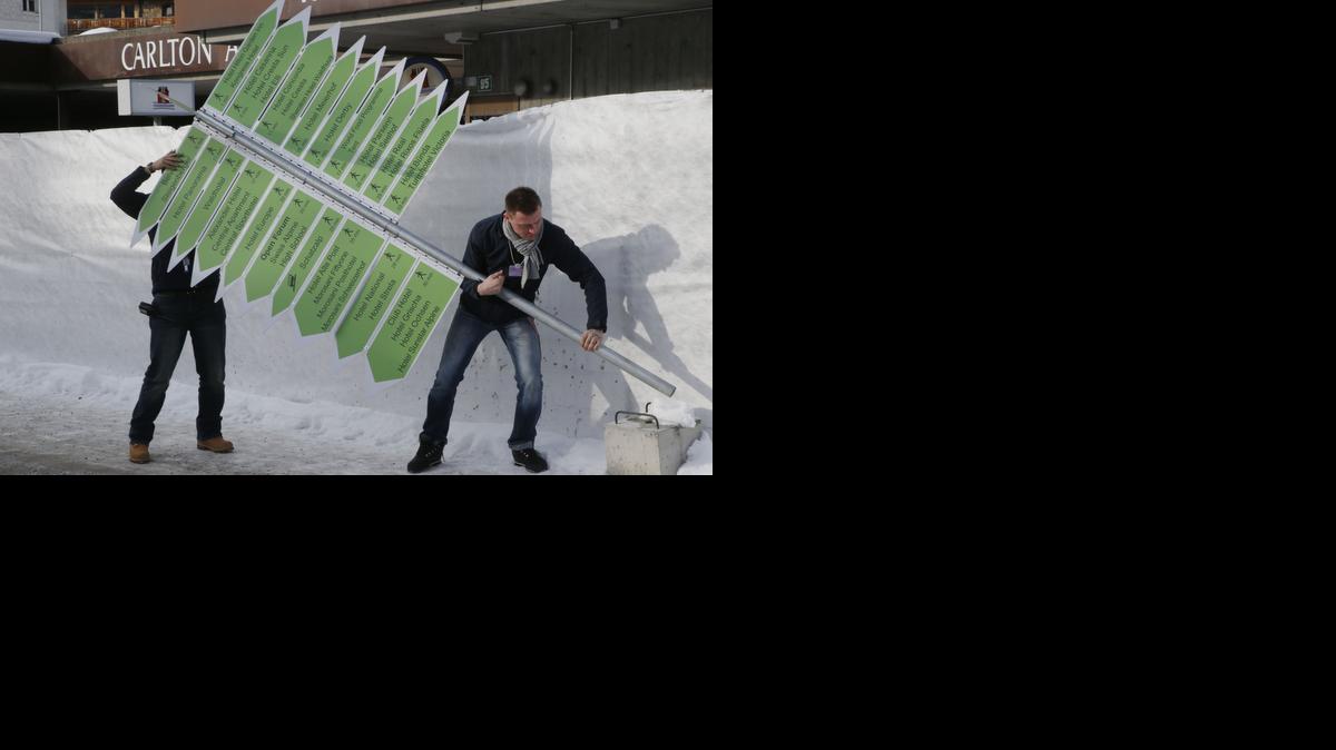 
Technicians set up signs outside the Congress Hall in Davos, Switzerland, Monday. The world’s financial and political elite will head this week to the Swiss Alps for 2015’s gathering of the World Economic Forum at the Swiss ski resort of Davos. 
