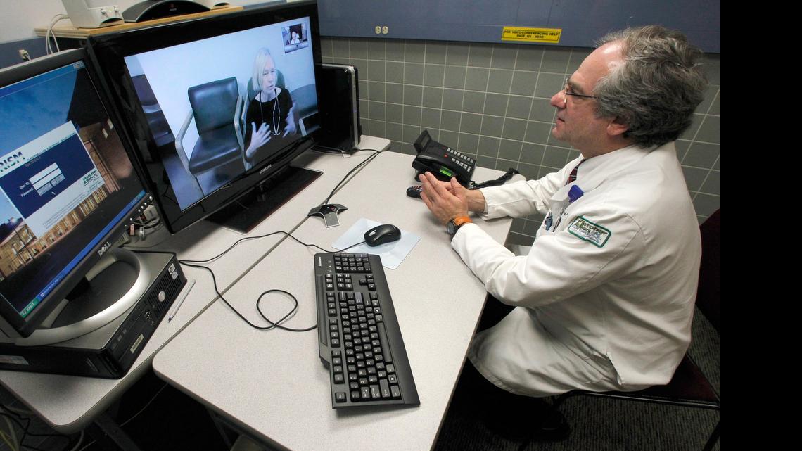 
Dr. Terry Rabinowitz, right, talks with nurse Leslie Orelup at Helen Porter Nursing Home in Burlington, Vt., in 2012. Doctors have used video feeds and other technology for years to treat patients in remote locations. But experts say growing smartphone use and customer demand are fueling a rapid expansion of telemedicine into everyday care the family doctor used to handle.
