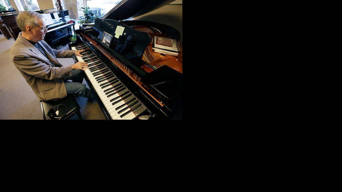 
Jim Foster plays a grand piano in his Foster Family Music Center piano store in Bettendorf, Iowa, in early December. The number of stores dedicated to selling pianos is dwindling across the country as fewer people take up the instrument and those who do opt for a used piano or a less expensive electronic keyboard. 
