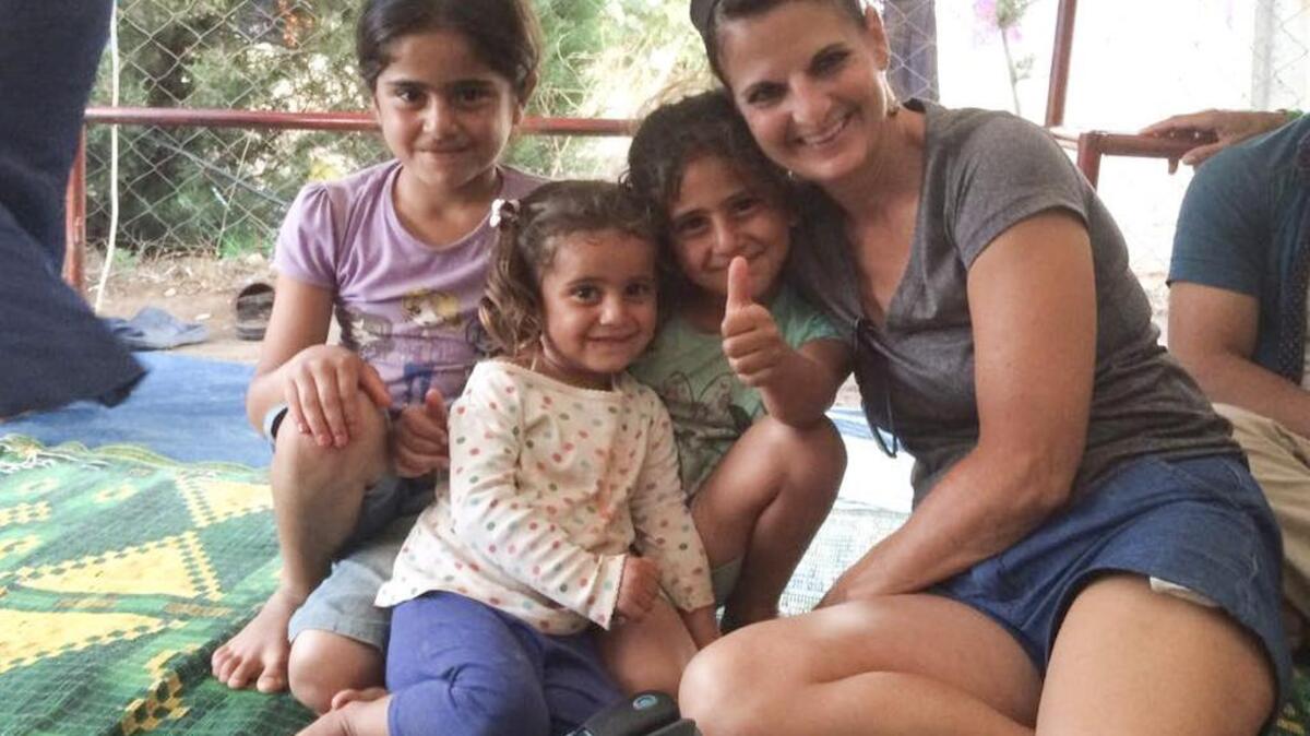 Michelle Ruebke, a midwife from Newton, sits with three children in a refugee camp near Izmir, Turkey. Ruebke has been in Izmir since June 26 providing medical attention to members of Turkey’s massive refugee population.