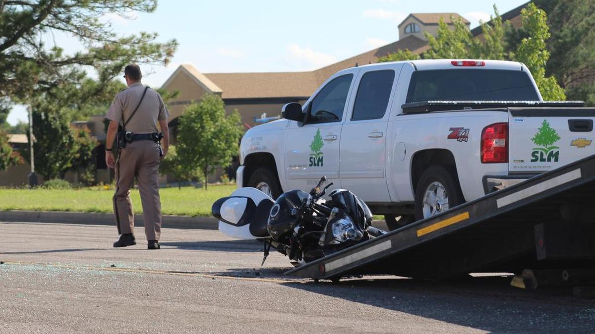 
A Wichita police officer examines a motorcycle before it is towed off of Webb Road. The rider of the motorcycle is in critical condition at Wesley Medical Center.
