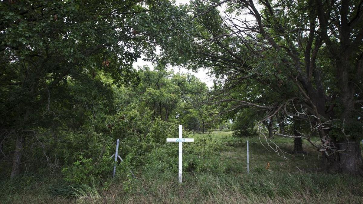 
A cross at mile marker 118 on the Kansas Turnpike marks the area where 21-year-old Zachary Clark of Keller, Texas, died when his car was swept into floodwaters in early July. The Kansas Turnpike Authority plans to expand drainage on a 2-mile stretch of the highway near Emporia where flooding has killed seven people since 2003. The design that will be used meets only the minimum standard, and it will give less protection than the standard used in some surrounding states.
