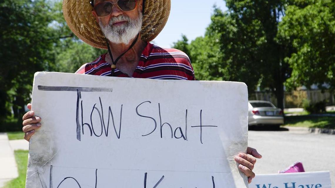 David Schmidt, with Coalition for Life, stands outside of Trust Women’s South Wind Women’s Center in Wichita. Schmidt stands at the entrance to the clinic three times a week. Schmidt brings his own sign that was drawn by his granddaughter. (June 27, 2016)