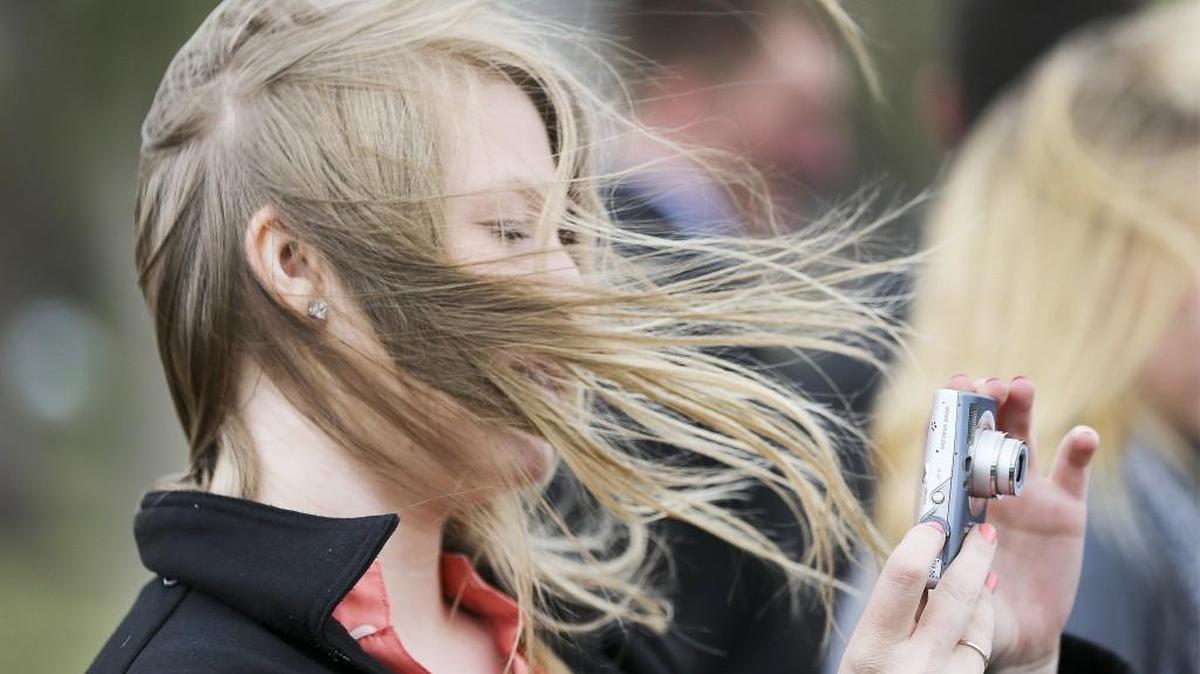 Mormon missionary Hermana Brusch fights the wind while taking a picture of the Keeper of the Plains Tuesday afternoon. (April 29, 2014)