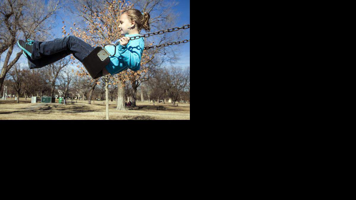 
Emily Calvin, 7, plays on a swing set Monday in Riverside Park. Record-high temperatures in the low 70s gave children who were off from school for the holiday – and parents – reason enough to spend the afternoon outside. (Jan. 19, 2015)
