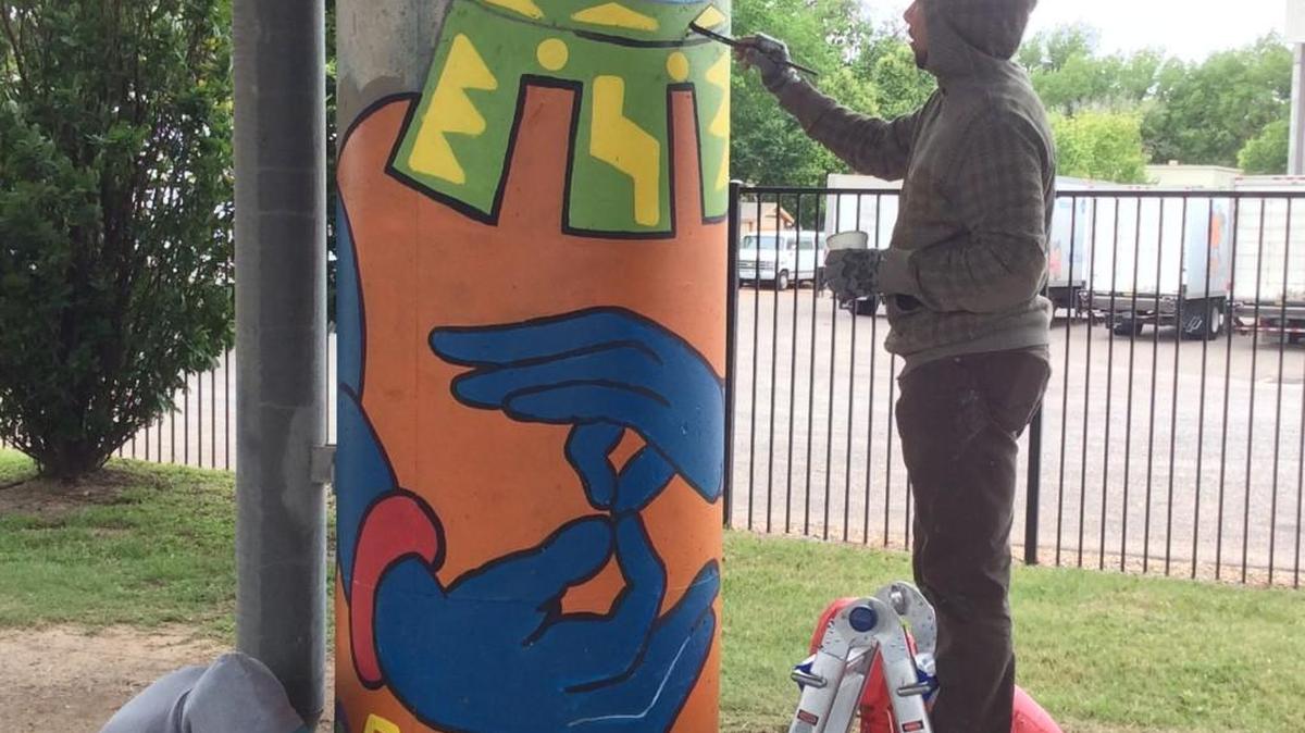 Artists paint a mural Sunday on a pillar supporting Interstate 135 over Douglas. (May 1, 2016)