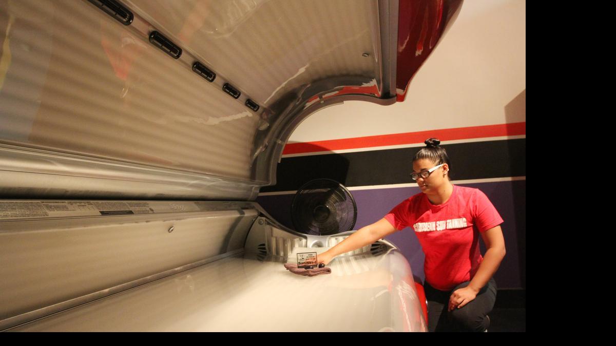 
Tyler Chastain, a spray tech at Caribbean Sun on East 21st Street, shows off one of the tanning beds available there. A new study says about 2 million fewer Americans were using tanning salons in 2013 compared with 2010. (July 13, 2015)
