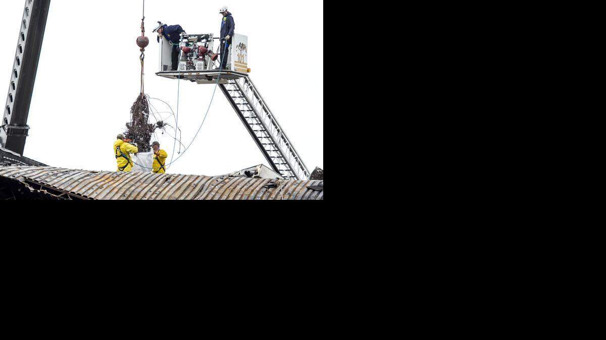 
Contractors hired by the National Transportation and Safety Board work to remove parts of the King Air that crashed into the roof of the FlightSafety building last week. (Nov. 3, 2014) 
