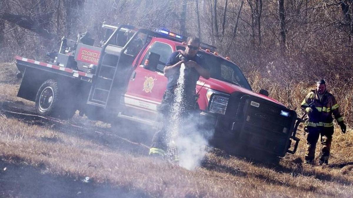 FILE - Sedgwick County firefighters douse a series of grass fires along K-42 in 2014.