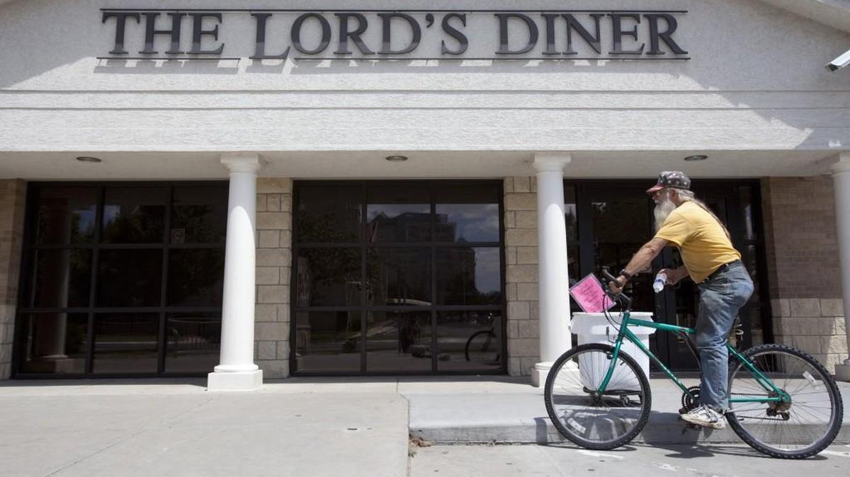 A man picks up a free bottle of water in front of the Lord’s Diner in Wichita. (2010)