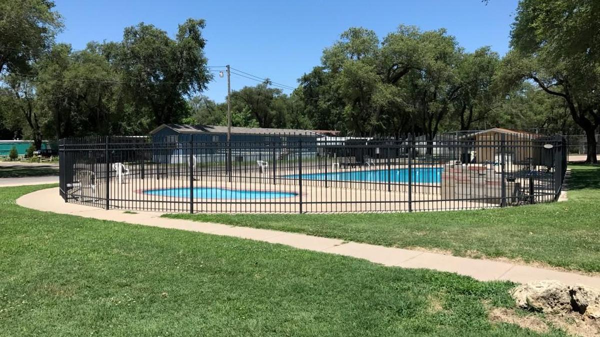 A passer-by pulled the woman from the Mobile Manor Estates pool. She was there with her small grandchild, police say.