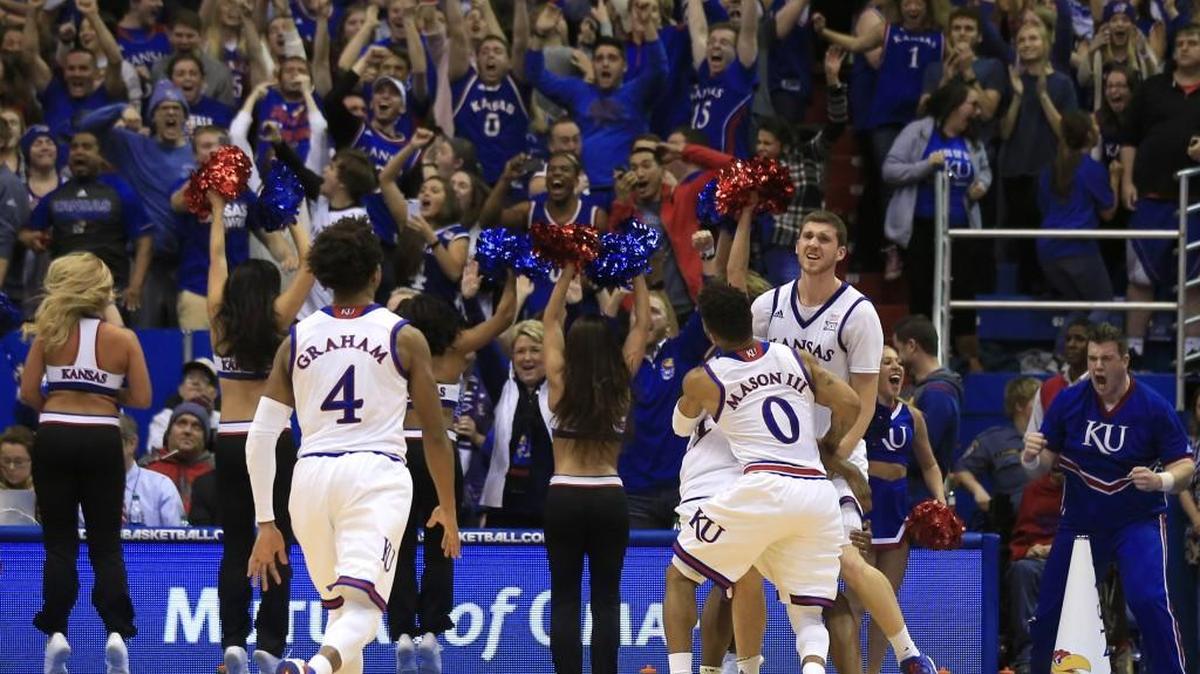 Kansas players Devonte’ Graham (4) and Frank Mason III (0) celebrate Tuesday with teammate Sviatoslav Mykhailiuk, right, after Mykhailiuk made the last-second game-winning basket against Kansas State in Lawrence.