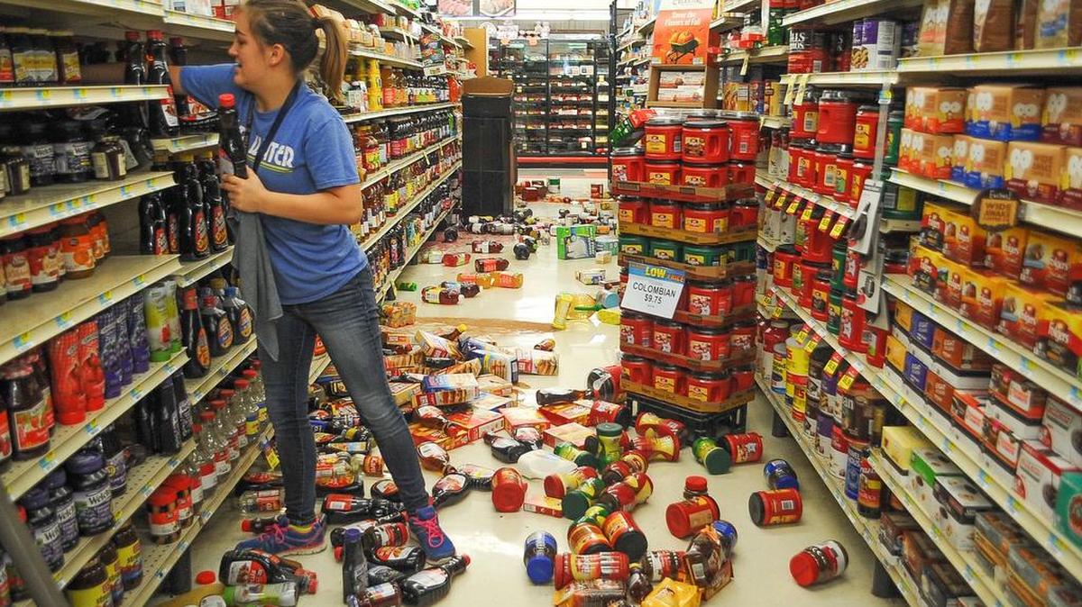 Employee Talia Pershall puts syrup back on a shelf while cleaning up at White’s Foodliner on Sept. 3, 2016, in Pawnee, Okla., following a 5.6-magnitude earthquake.
