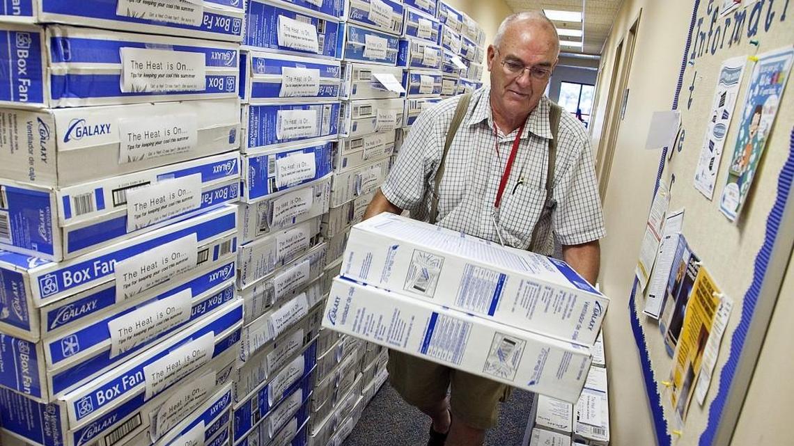 Volunteer Jim Cunningham stacks free fans during a giveaway in Wichita in 2013.