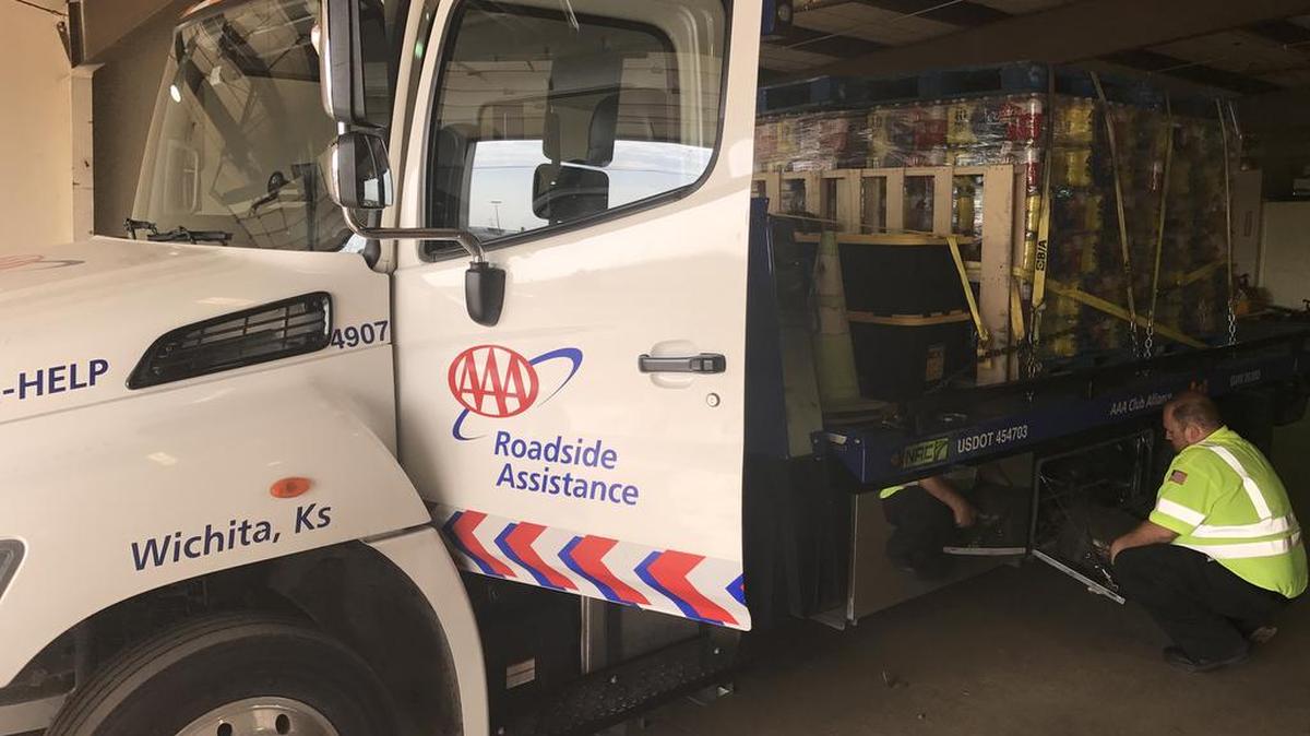 Cases of bottled water and other relief supplies are loaded onto one of the two tow trucks heading to Houston to assist with hurricane recovery efforts.