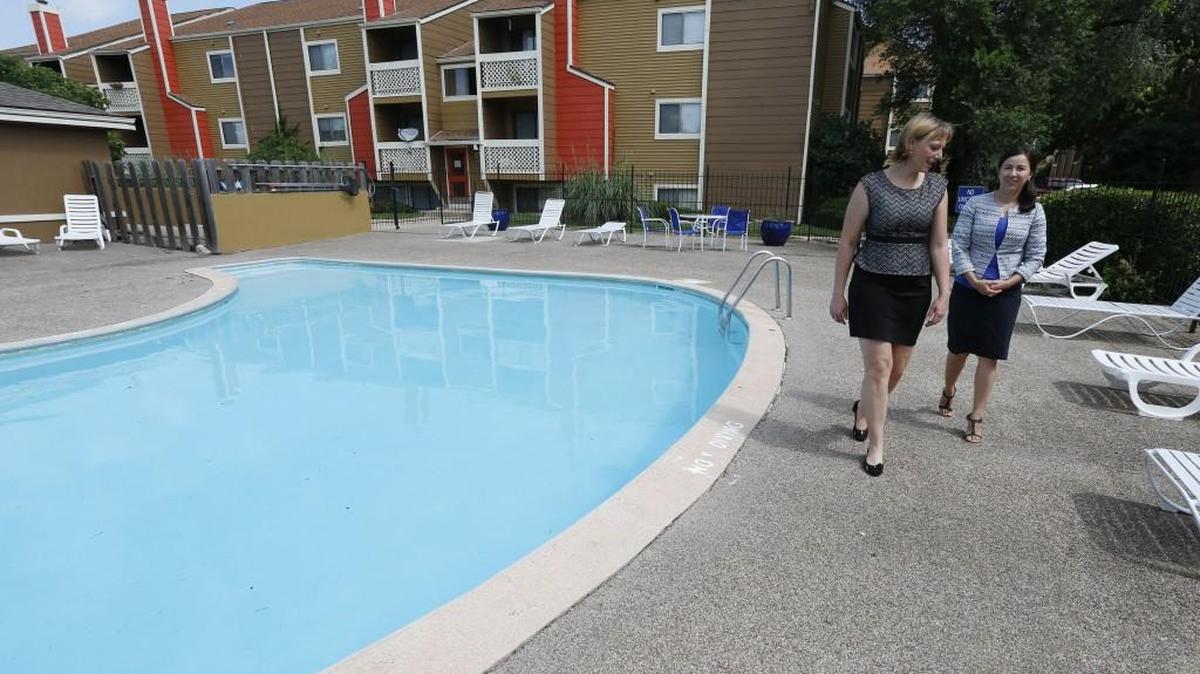 Glenda Flores, right, property manager at Village Park at Cedarbrooke and assistant manager Sara Wacker walk around the pool at the apartments. Additional security measures were taken this year to keep nontenants out of the pool, Flores said. (July 7, 2016)