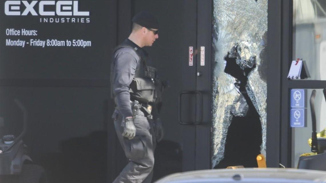 An investigator walks around the front entrance of Excel Industries in Hesston. (Feb. 26, 2016)