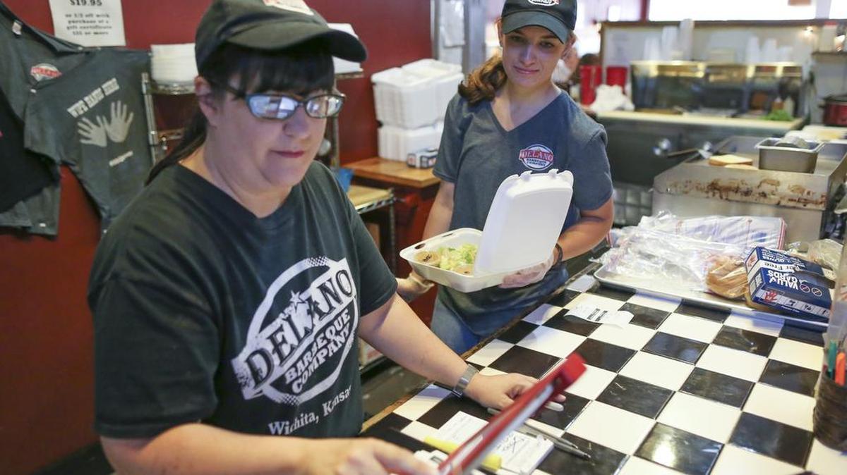 
Gabriella Hendren, right, and Anisa Jalil work behind the counter at Delano Barbeque Co. on Wednesday. Michelle Suddeth, a co-owner of the restaurant with her husband, Jon, estimated their wages average $8.60 per hour. 
