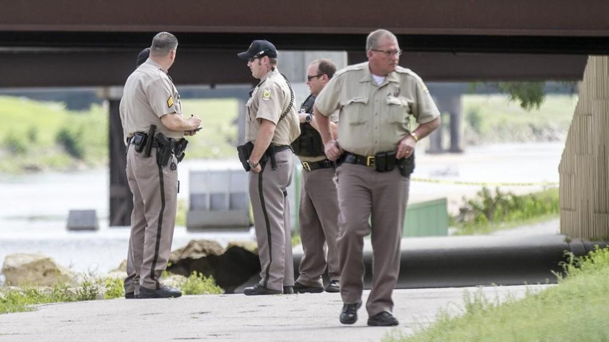Police investigate the scene where a caller reported seeing a body floating in the Arkansas River near the Lincoln Street Bridge on Monday. (April 25, 2016)