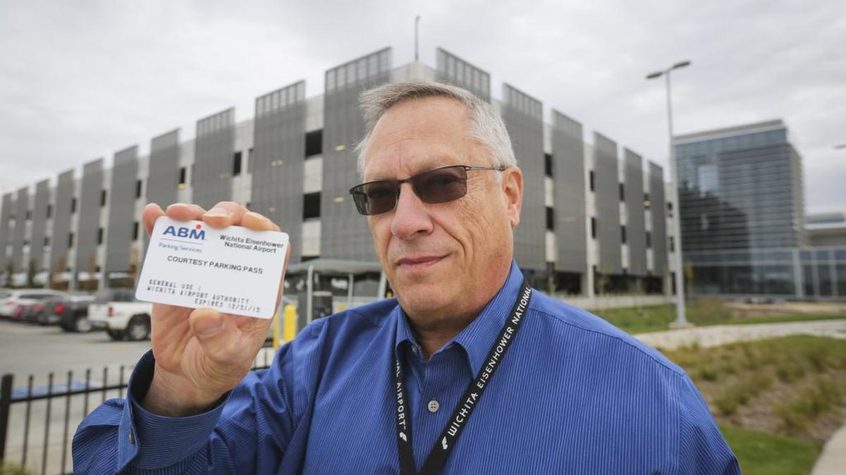 Wichita Airport Director Victor White holds a courtesy parking card outside the new Wichita Eisenhower National Airport parking garage. The airport is revamping its policies on who gets free parking at the airport garage and parking lots.