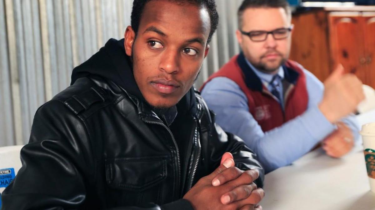 Somali refugee Mursal Naleye, left, sits with Benjamin Anderson at the African Shop in Garden City. Doctors have become so important to the Somalis that when Naleye learned that Anderson and two physicians were going to Africa in November, he felt obligated to join them.