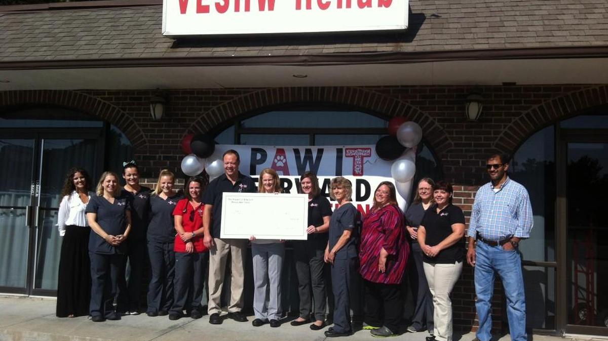 Staff of the Veterinary Emergency and Specialty Hospital of Wichita pose Thursday with a giant $80,000 check for the “Paw It Forward” fund for financial assistance to pet owners. Veterinarian Chrsiten Skaer presented the check, a gift from the Pamela J. Edwards Revocable Trust.