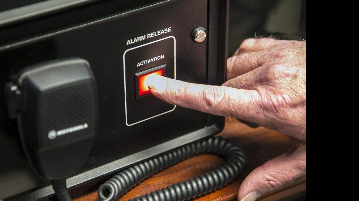 
John Crosby, deputy director, Sedgwick County Emergency Management, points to the manual override button for tornado sirens if computers fail. 
