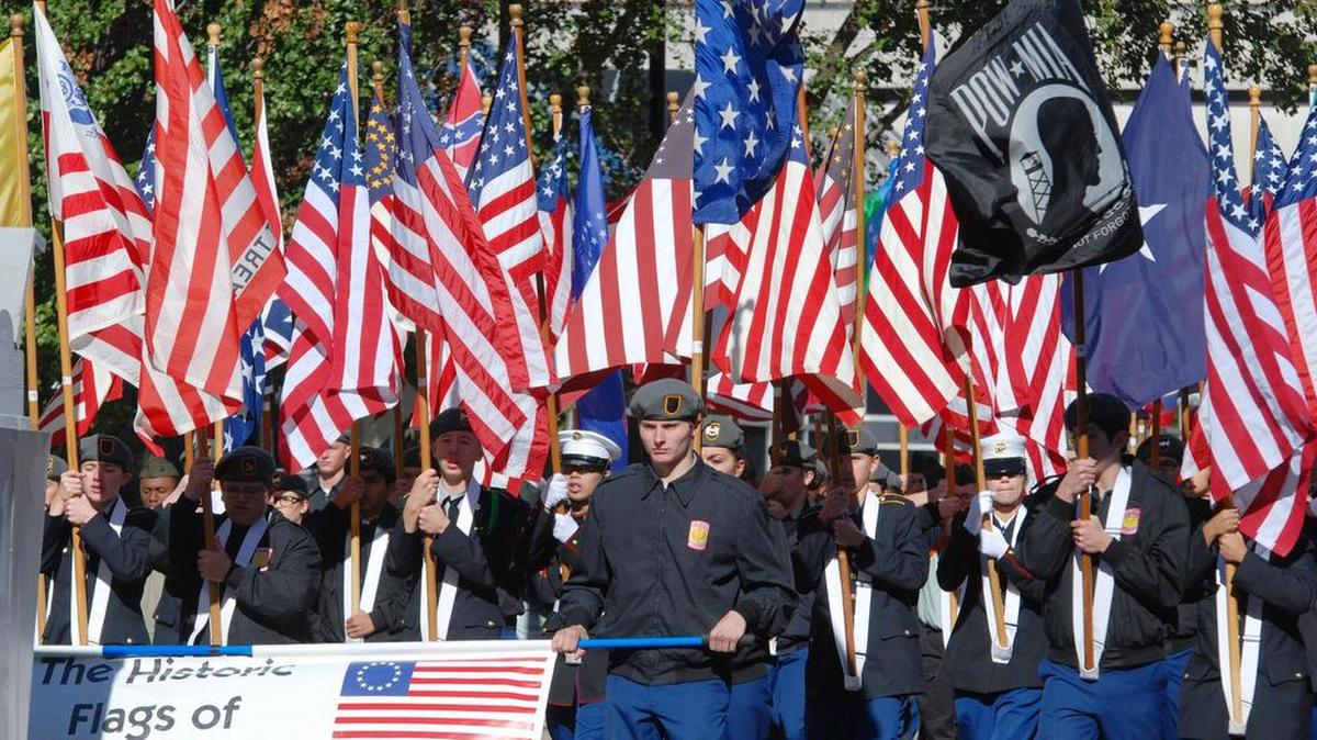 Flags from different periods are carried during the Veterans Parade in downtown Wichita in 2013.