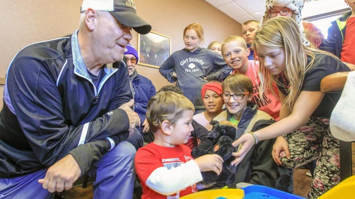 Erynn Howard, right, a fifth-grader at Rex Elementary School in Haysville, hands leukemia patient Grayson Westeman, 3, center, a stuffed gorilla at David Rosen’s Oncology Clinic earlier this month. Erynn, along with 15 other representatives from the school, raised money for Gold Glove Charities, which is run by Mike Martin, left, who founded the charity to raise money for awareness of pediatric cancer.