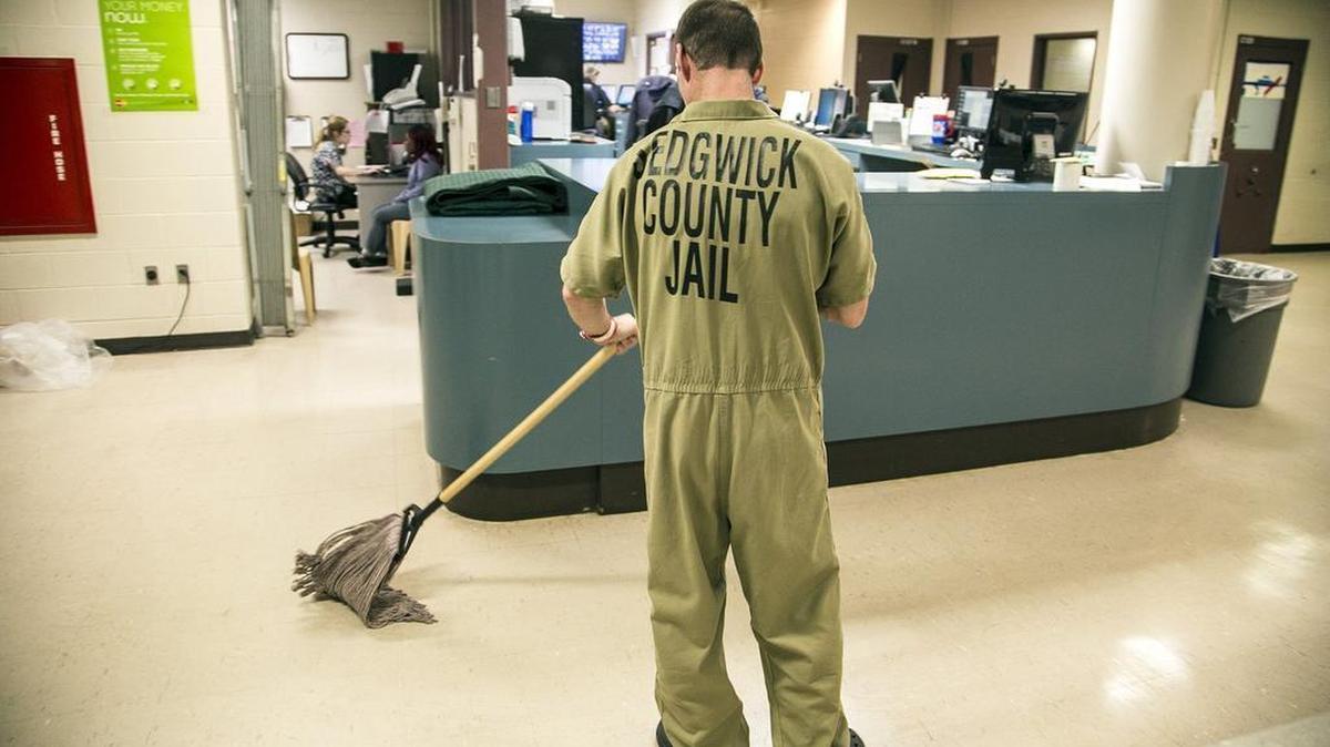 A trusty mops the booking room on Christmas in the Sedgwick County Jail.