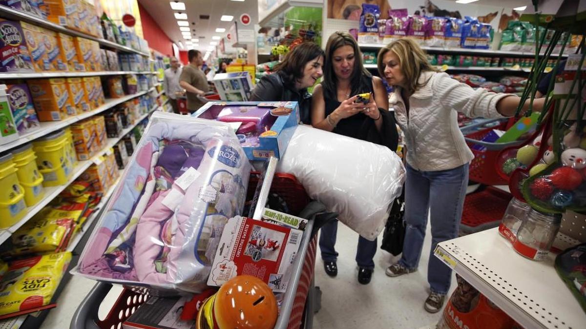 Target shoppers use a smartphone to check competitor’s prices while shopping after midnight on Black Friday.