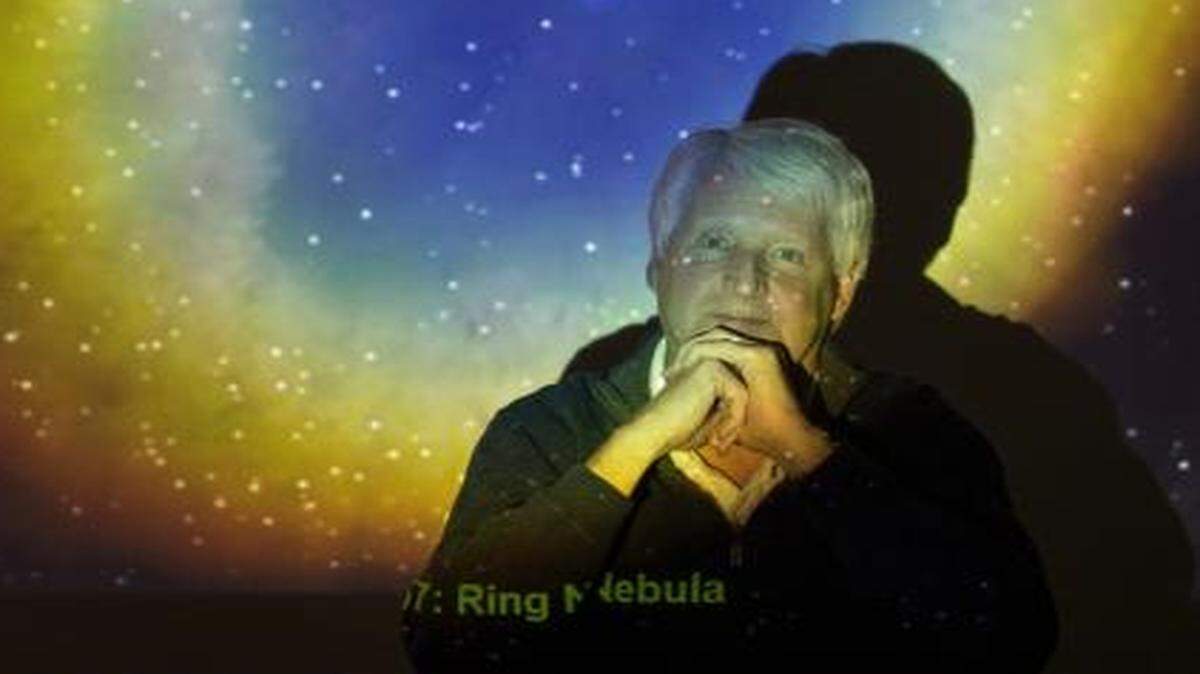 
University of Kansas professor, Dr. Steve Hawley, sits in front of a projected photo of the Ring Nebula that was taken with the Hubble Space Telescope. Hawley, an astronomer and astronaut, made five flights into orbit on the Space Shuttle and was the person who deployed the Hubble Space Telescope into orbit.
