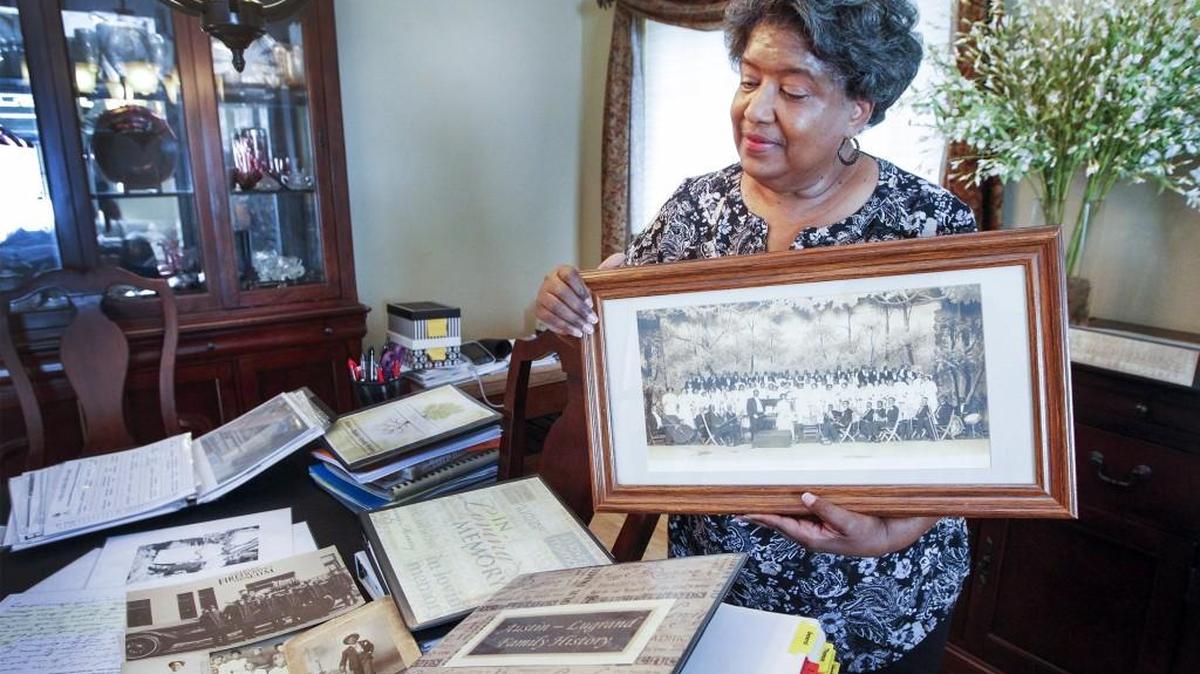 Wichita genealogy researcher Jackie Lugrand holds up family pictures from long ago at her home in east Wichita. In addition to investigating her own and others’ genealogy, Lugrand volunteered with a project indexing documents from the Freedmen’s Bureau, a database of post-Civil War documents.