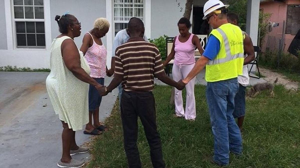 Employee Brad Kesl prays with a group in Miami when Westar Energy restored their power a week after Hurricane Irma hit the state.