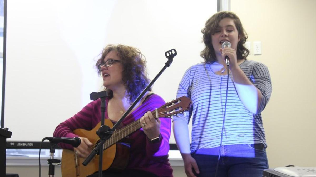 Isabella Parker, 17, right, sings with her mother Natasha Helfer Parker during a gathering of Wichita Oasis.