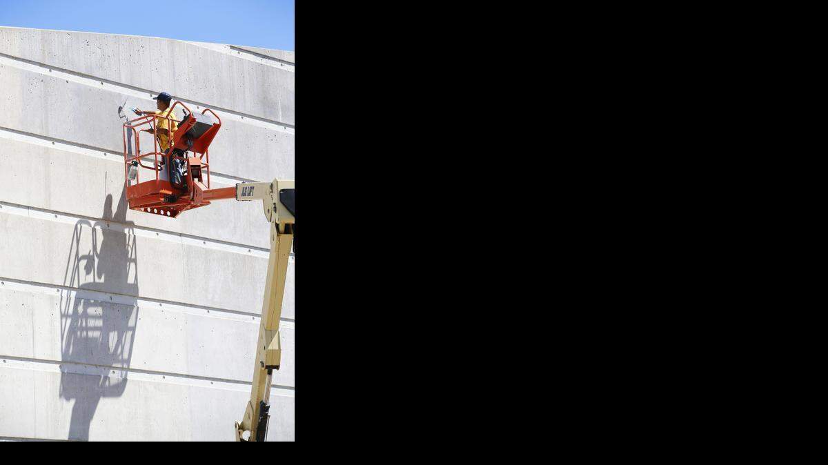 
Gabriel Rivas, with Restoration and Waterproofing, applies a darker stain to the exterior of Exploration Place. (Aug. 25, 2014)
