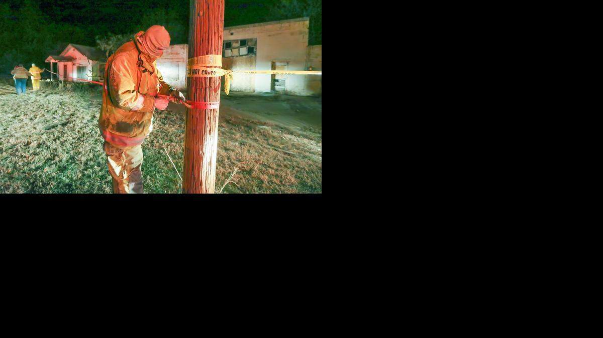 
Argonia firefighter Justin Stringer strings crime-scene tape around some buildings in the town of Milan, Kan., after a 4.8-magnitude earthquake hit nearby on Nov. 12. 
