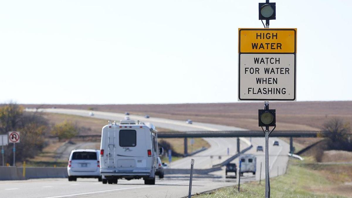 Signs and warning lights warn drivers of high water in two spots along the Kansas Turnpike south of Emporia last fall. (Nov. 6, 2015)