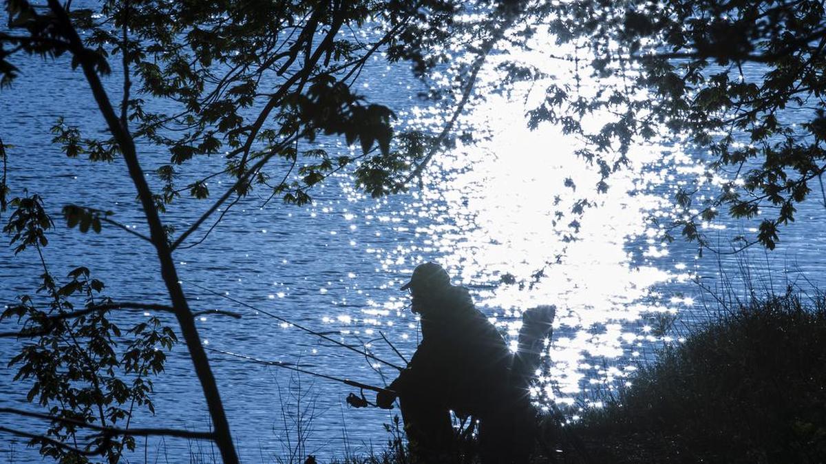 Vernon Ake fishes for carp just after sunrise along the Little Arkansas River in April.