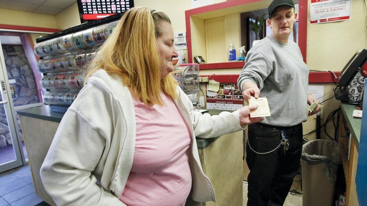 Beverly Collins, left, buys a lottery ticket from Dana Leis at the Heritage Restaurant in south Wichita on Tuesday.