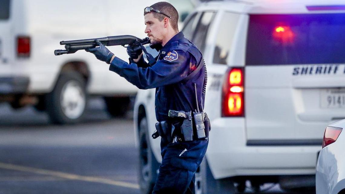 Police go through the parking lot of Excel Industries in Hesston on Feb. 25, where a gunman killed three co-workers and wounded 14 others before being killed by Hesston’s police chief.