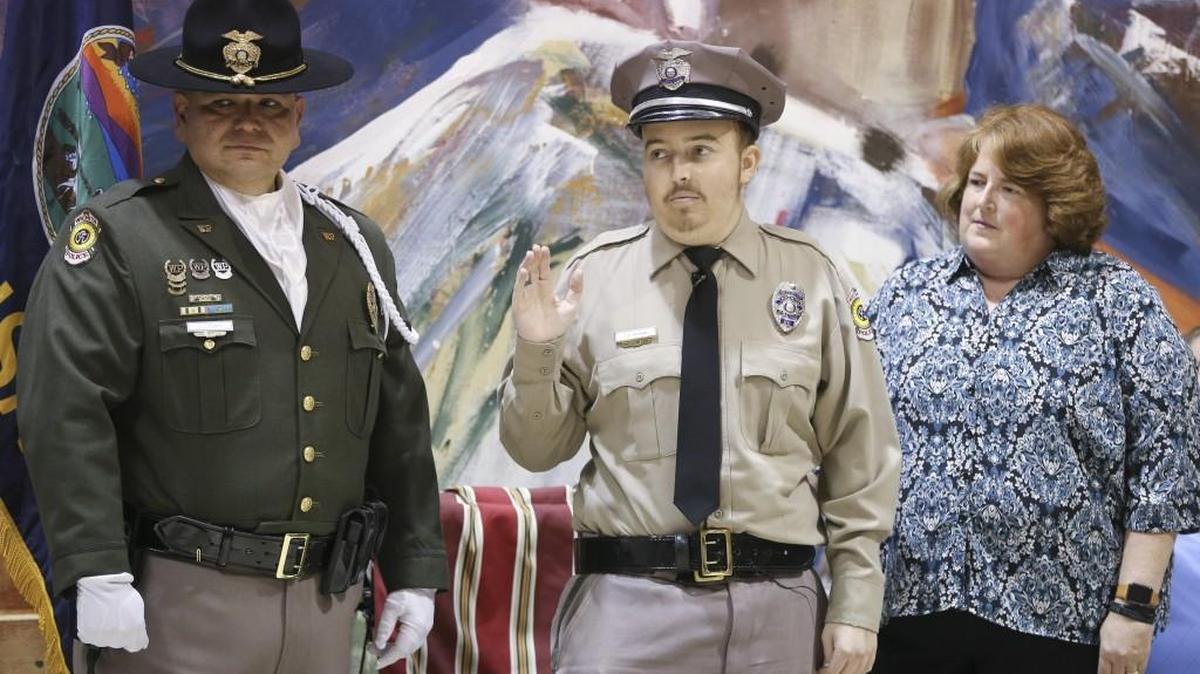 Caleb Moraine, middle, is sworn in by Police Chief Gordon Ramsay during a special ceremony on Wednesday, Nov. 8, 2017, at the Evergreen Recreation Center. Moraine had always dreamed of being a police officer.